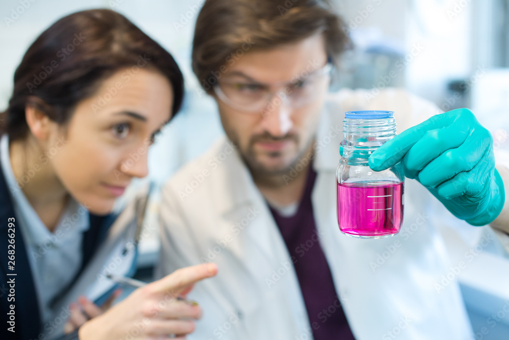 two scientists doing experiments with chemical liquid in the lab two scientists doing experiments with chemical liquid in the lab