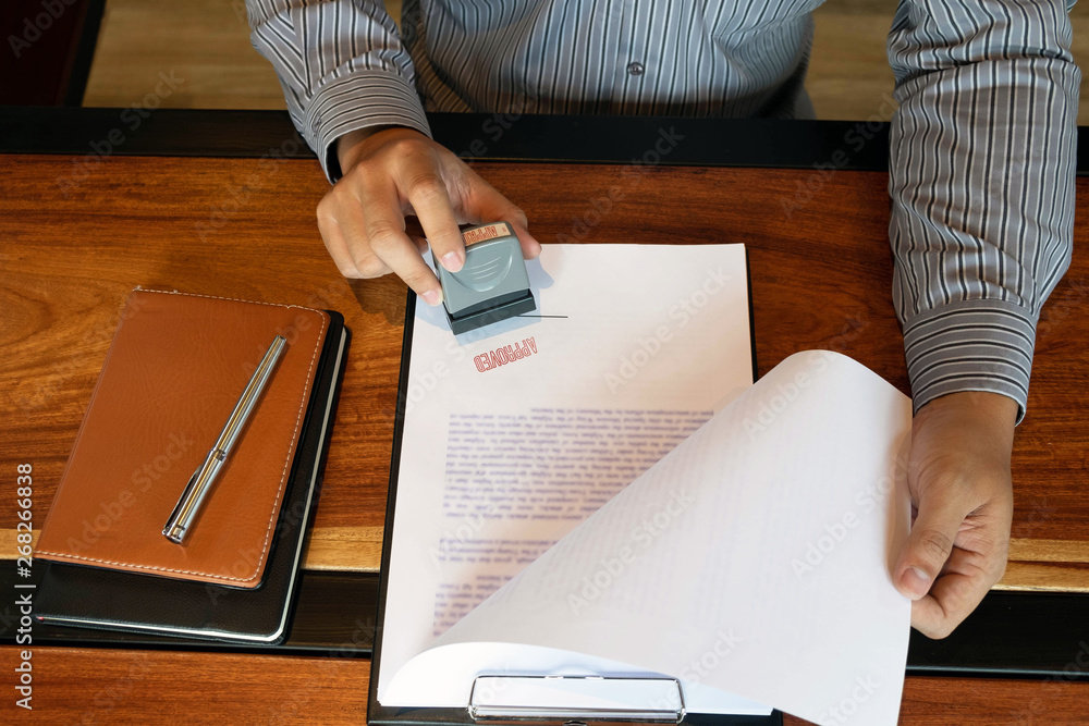Φωτογραφία Close-up pictures of the hands of businessmen signing and stamping in approved c