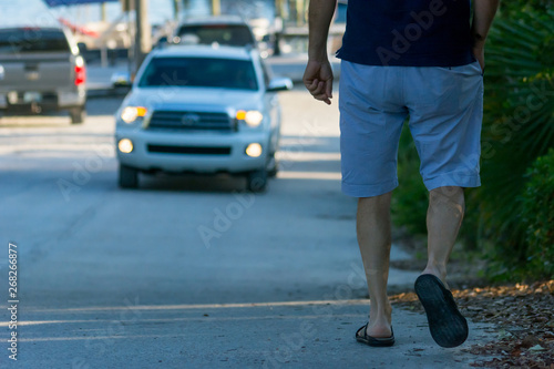 Man Walking on the Street on Blur Car Background. Destin Beach, Florida