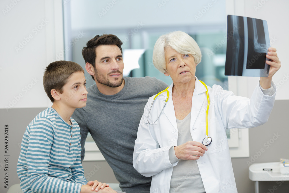 woman doctor with x-ray and patients behind woman doctor with x-ray and patients behind