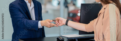 Banner and cover scene of Closeup Asian receptionist hand recieving the automatic car key for checking at maintainance service center for in showroom photo