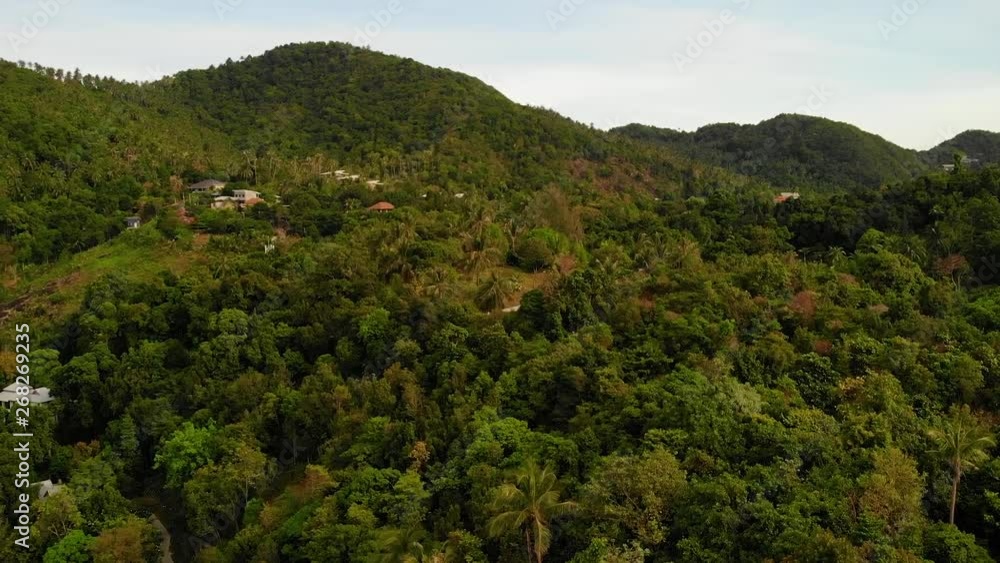 Villas on green mountain ridge. Majestic drone view of luxury villas located on green mountain range on tropical paradise exotic island Villas on green mountain ridge. Majestic drone view of luxury villas located on green mountain range on tropical paradise exotic island