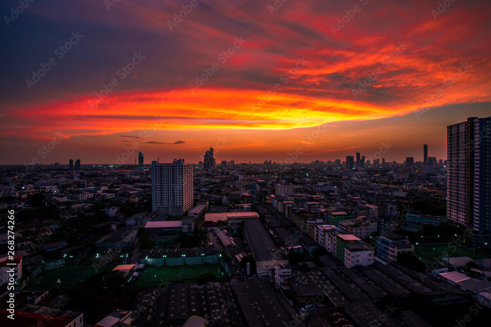 Obraz premium Panorama background of city views, with colorful twilight sky, high-rise buildings (condominiums, offices, expressways) and blurred lights from roads and traffic.