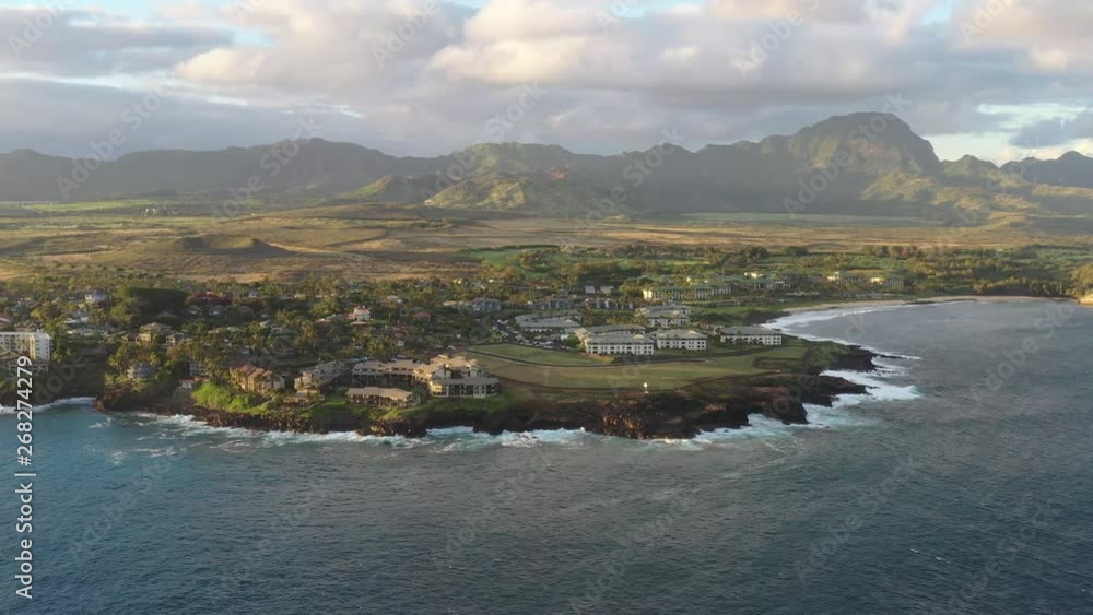 An aerial sweeping sunset view of a mountainous tropical island, Poipu, Kauai An aerial sweeping sunset view of a mountainous tropical island, Poipu, Kauai