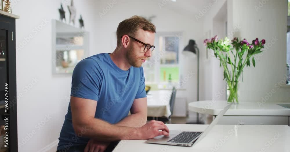4K Attractive red haired man with glasses working on laptop at home. Slow motion 4K Attractive red haired man with glasses working on laptop at home. Slow motion