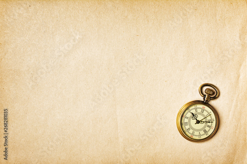 Vintage bronze pocket watch on yellowed paper