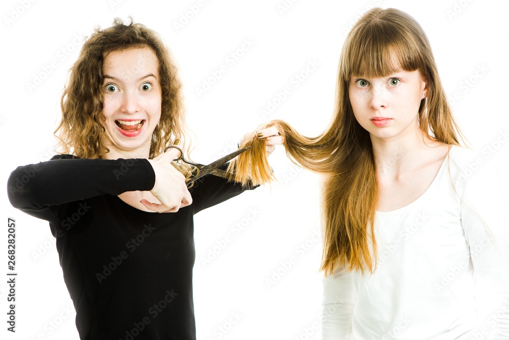 Two girls with blond hairs and scissors, one going to cut hairs Two girls with blond hairs and scissors, one going to cut hairs