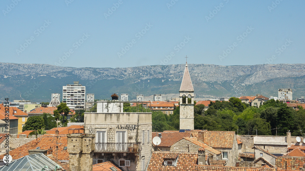 Scenic aerial view of the city from the bell tower, roofs of houses and church in old town, beautiful cityscape, sunny day, Split, Croatia