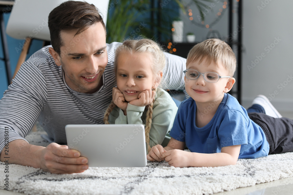 Young father with little children watching cartoons at home Young father with little children watching cartoons at home