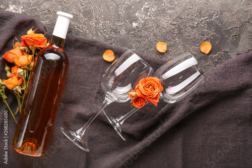 Bottle of wine, glasses and flowers on grunge background