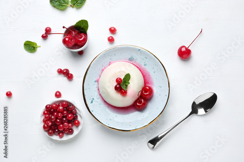 Plate with tasty panna cotta on white table photo