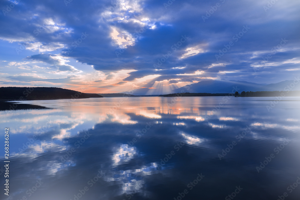 Fototapeta premium Incredibly beautiful sunset.Sun,sky,lake.Sunset or sunrise landscape, panorama of beautiful nature. Sky with amazing colorful clouds.Water reflections.Magic Artistic Wallpaper.Blue Background.Light.