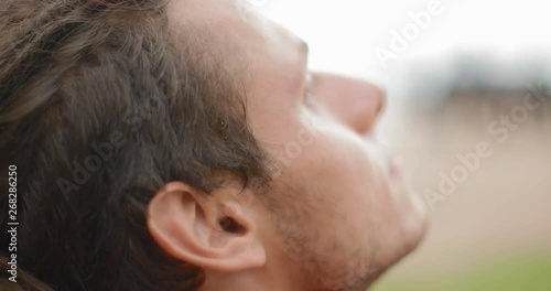 A young man thoughtfully raises his head to the top and looks to the sky. in slow motion. Shot on Canon 1DX mark2 4K camera