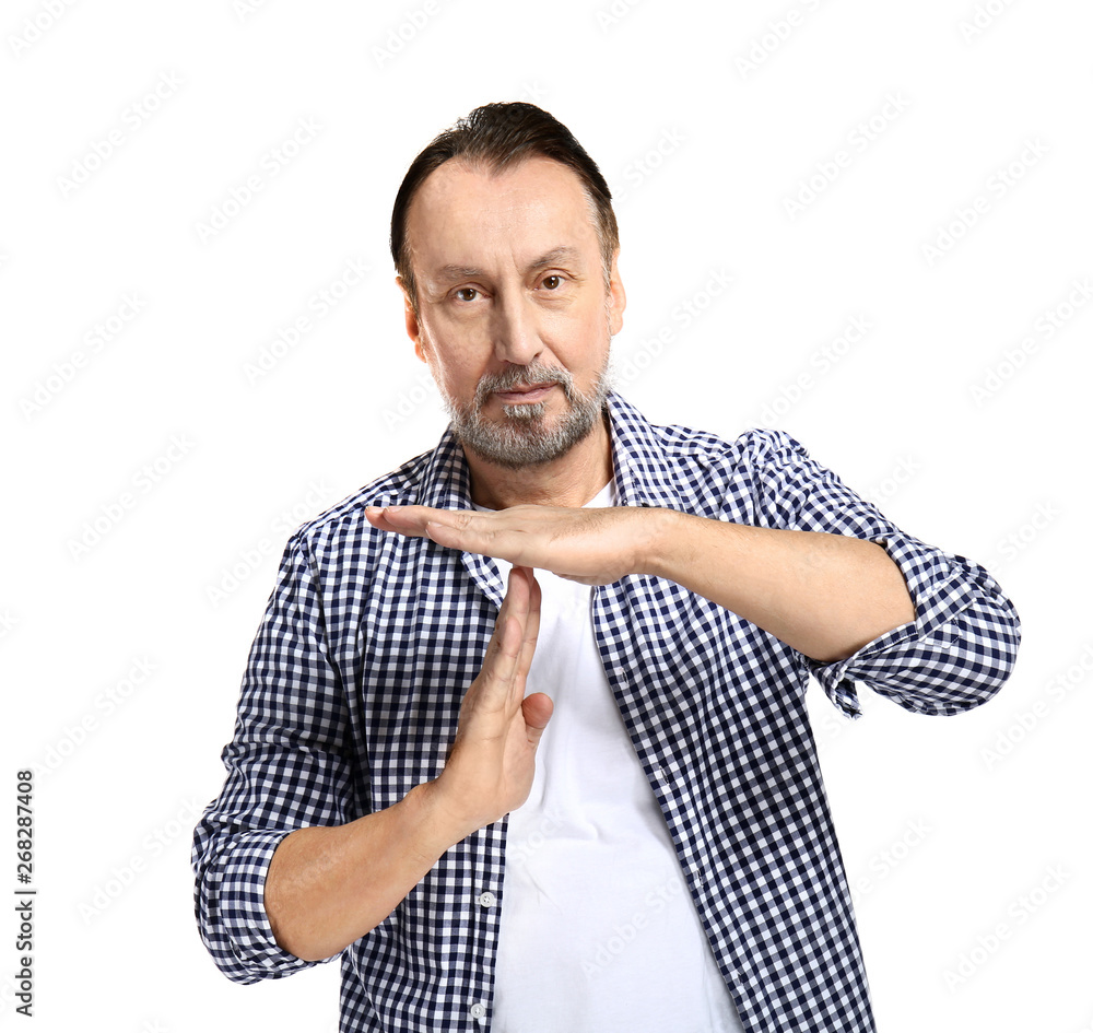 Portrait of handsome mature man showing time-out gesture on white background
