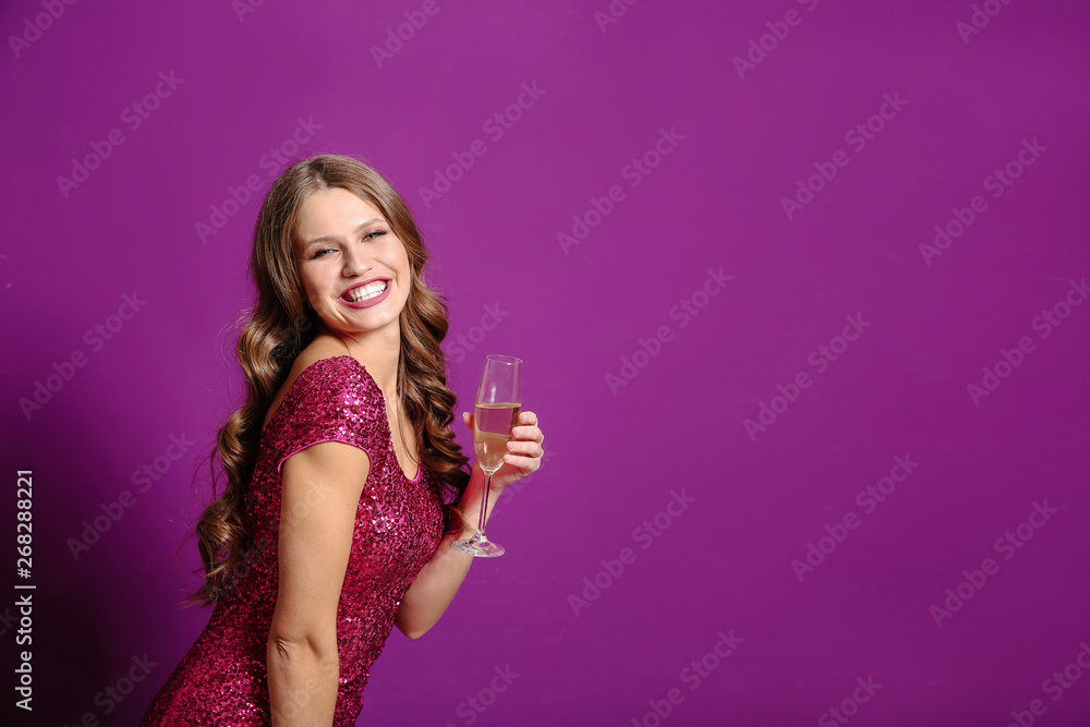 Beautiful young woman with glass of champagne on color background Beautiful young woman with glass of champagne on color background