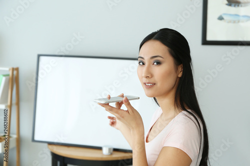 Young Asian woman with mobi...