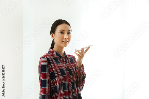 Young Asian woman with mobi...