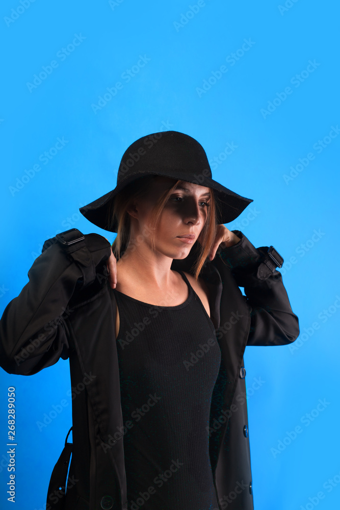 A woman throws a black cloak over her shoulders. Autumn look. The girl is going for an autumn walk A woman throws a black cloak over her shoulders. Autumn look. The girl is going for an autumn walk