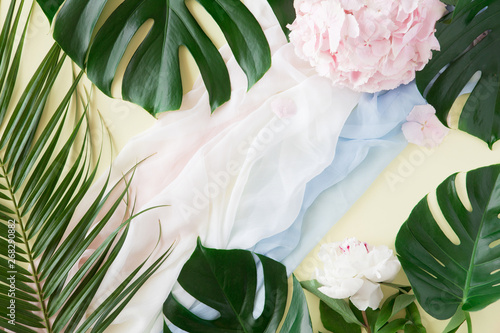 Creative layout and background made of tropical palm leaves and pink pastel f...