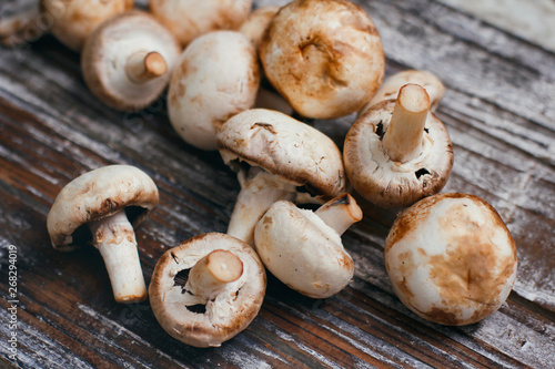 Set of champignon mushrooms on wooden background table. 
