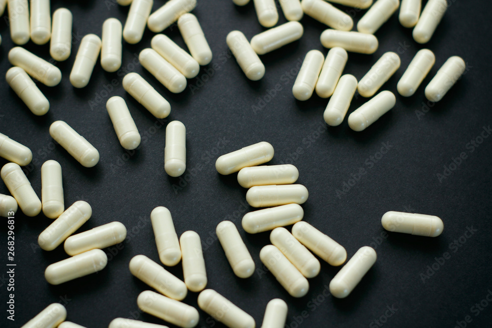 Set of white pills on black background. Pattern texture. Set of white pills on black background. Pattern texture.
