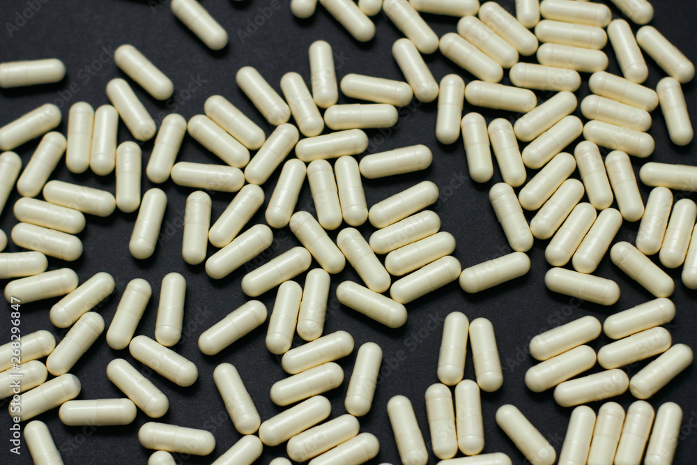Set of white pills on black background. Pattern texture. Set of white pills on black background. Pattern texture.