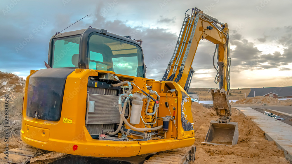 Construction site with an excavator against a dramatic sky filled with clouds Construction site with an excavator against a dramatic sky filled with clouds