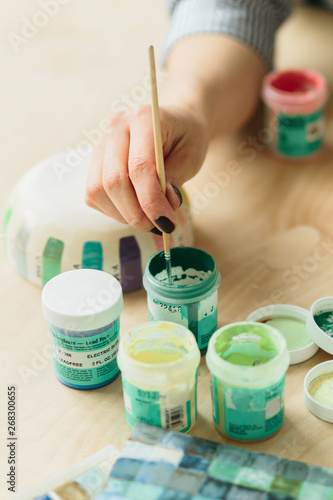 Potter holds the color palette glazes for coating ceramic products