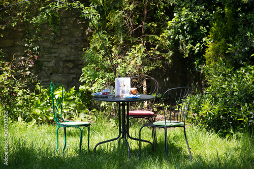 cafe table and chairs in the sunlit garden