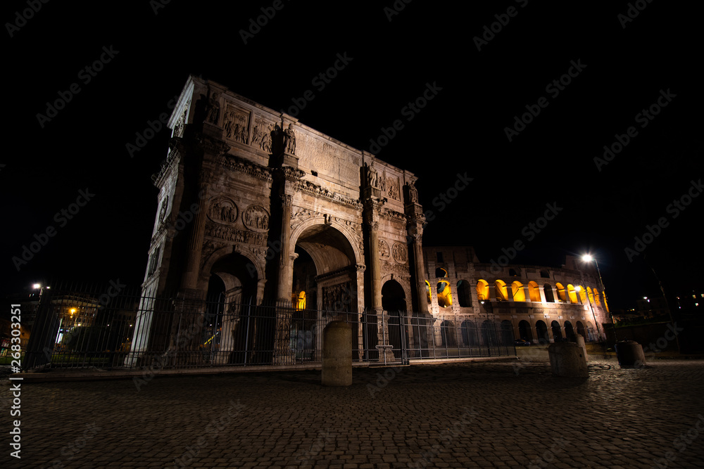 Arch of Constantine with the Colosseum in the background in Rome - Italy