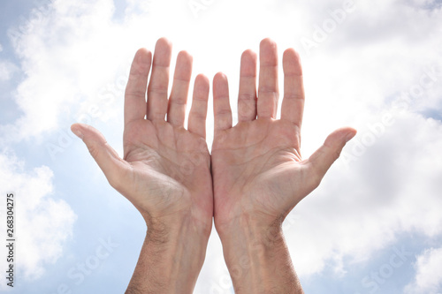 open man's hands rising to the sky in a pray gesture with copy space for your text