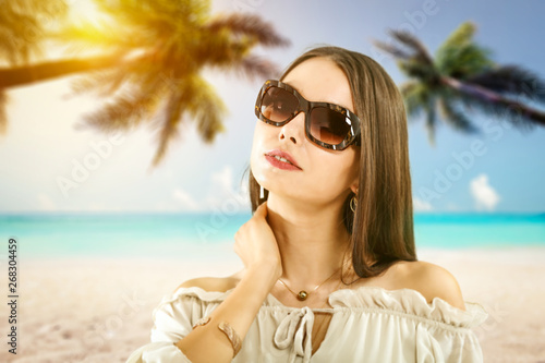 Slim young woman with sunglasses on beach with palms. Summer time  © magdal3na