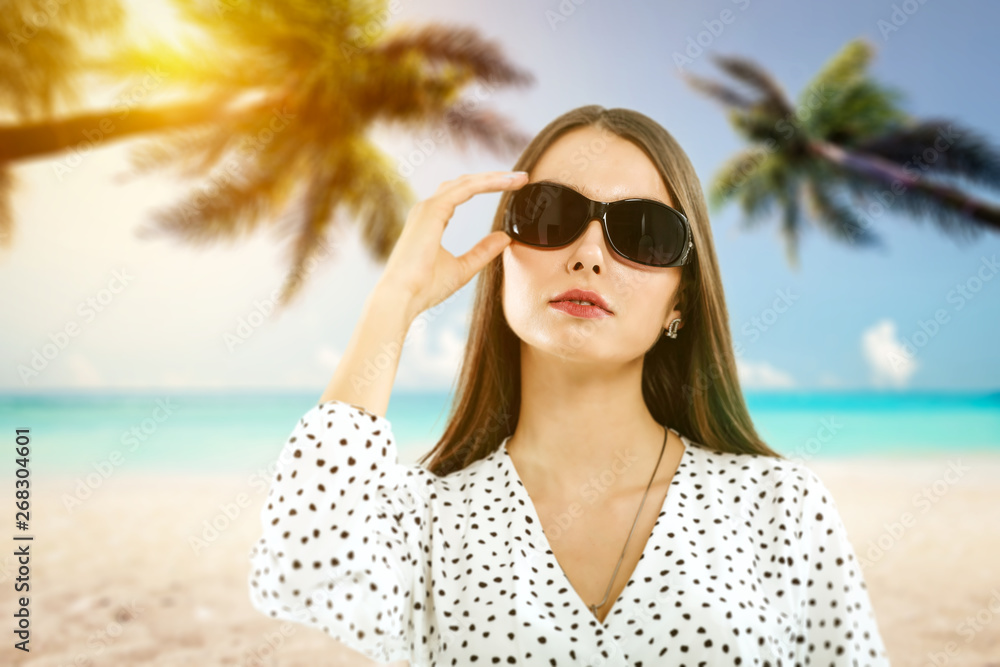 Slim young woman with sunglasses on beach with palms. Summer time Slim young woman with sunglasses on beach with palms. Summer time