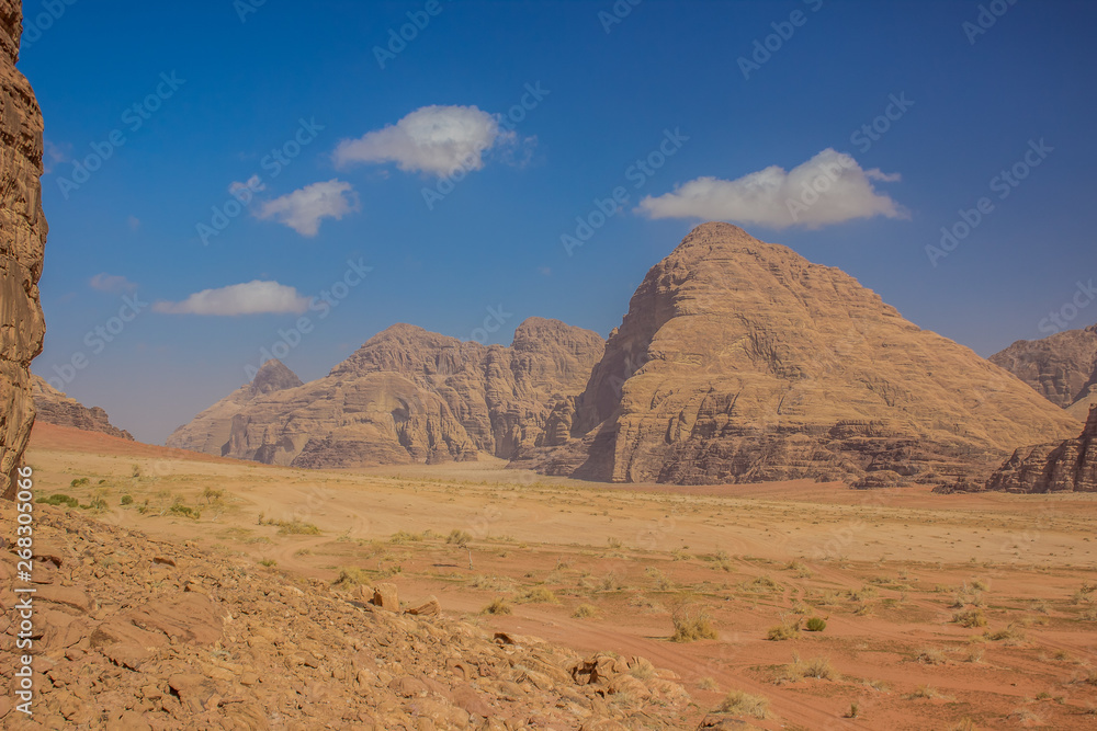 beautiful Middle East desert valley scenery landscape place for touristic tours with picturesque bare sand stone mountain ridge background, bright yellow and blue photography 