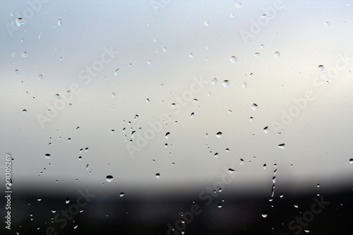 Rain drops on window with blured background.