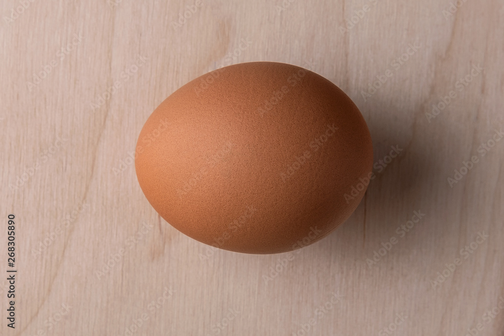 Lonely chicken egg on a wooden background Lonely chicken egg on a wooden background
