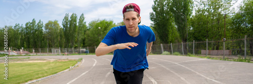 close up head portrait of a man running on a stadium track, fast speed motions
