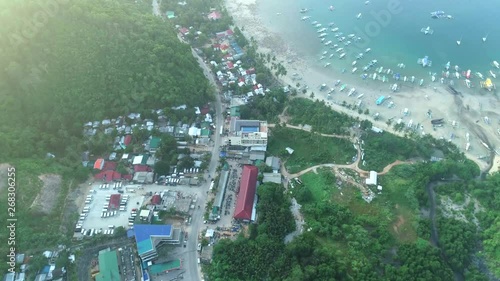 Aerial top view of philippines village on the beautiful tropical seashore, boats anchored in the bay with clear and turquoise water. Tropical landscape. El Nido, Palawan island, Philippines. photo