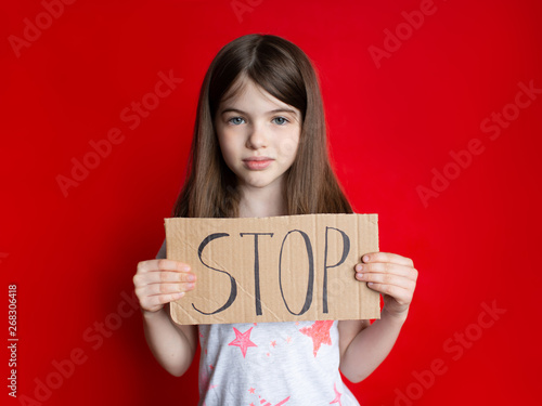 girl holding a stop sign, isolate on a red background