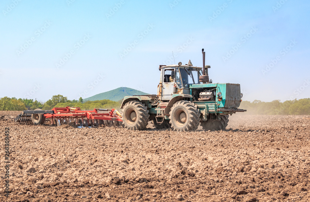 The tractor plows the soil. The tractor plows the soil.