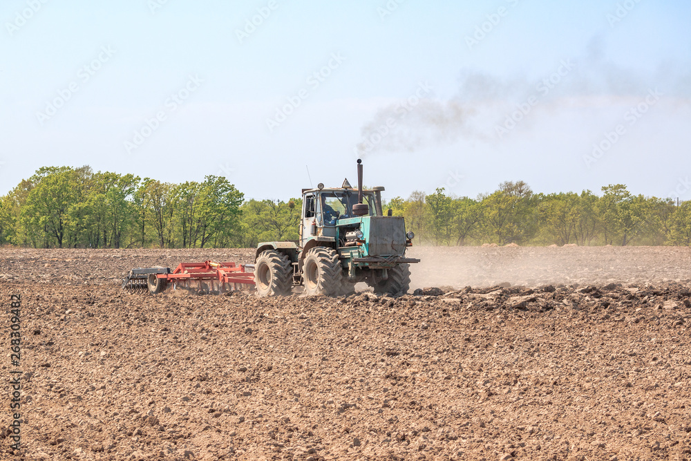 Fototapeta premium The tractor plows the soil.