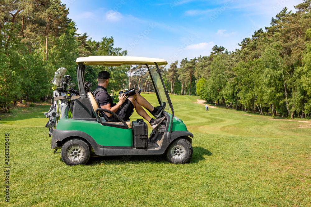 Golf Fotograf auf Fairway in einem Golfcart