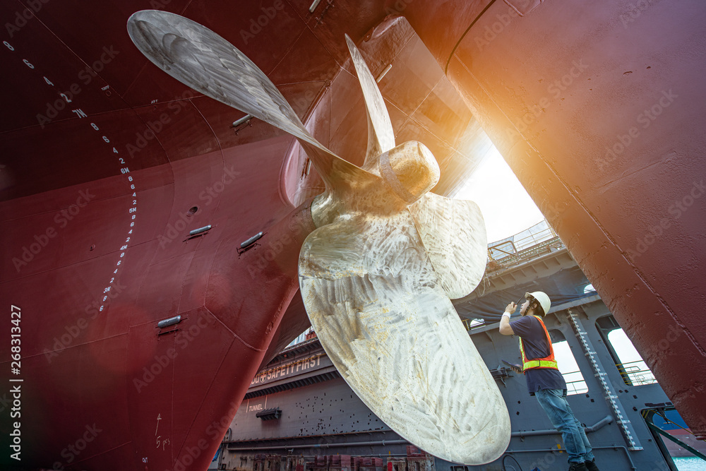 Stevedore, controller, Port Master, surveyor inspect theaft stern propeller of the ship in floating dry dock, recondition of overhaul repairing and painting, sand blasting in dry dock yard - obrazy, fototapety, plakaty 