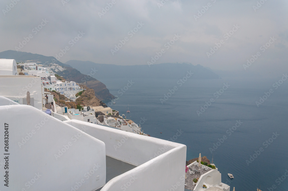 Fototapeta premium Panorama of Oia white houses with caldera immersed in the mist