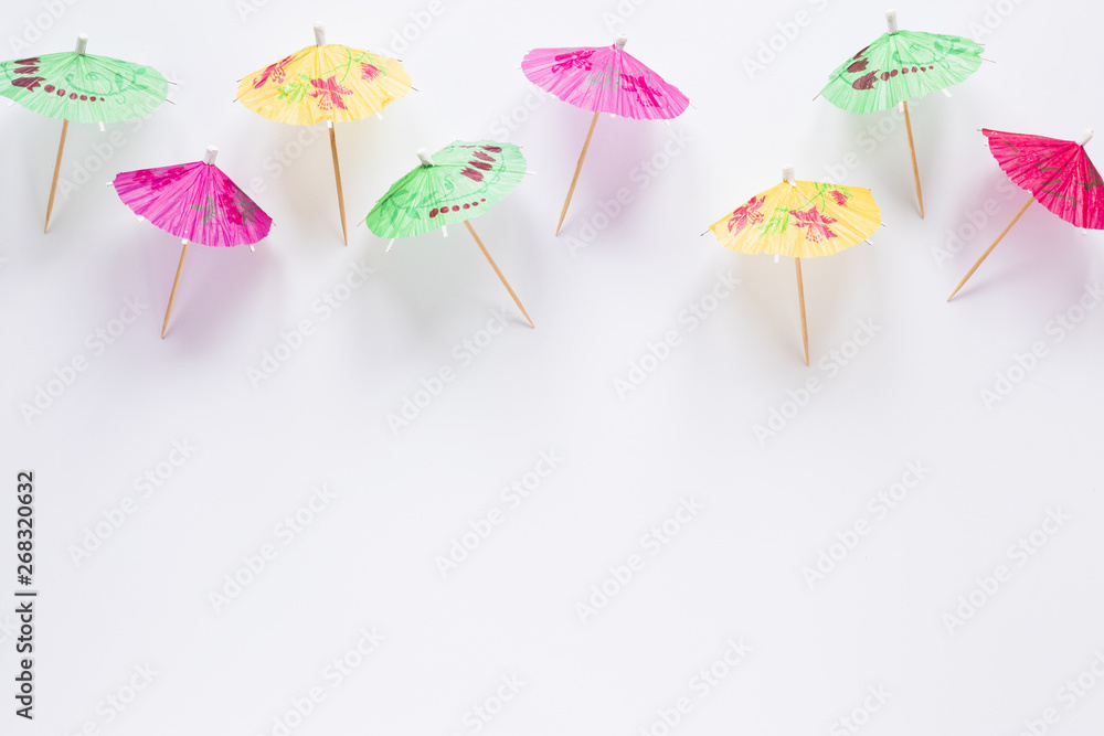Many bright cocktail umbrellas on table