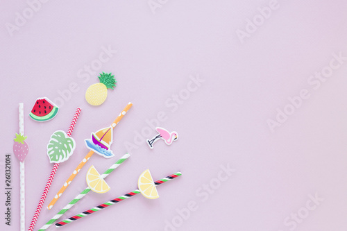 Different plastic straws on pink table
