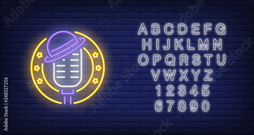 Stage neon icon. Mic with hat in circle frame with stars on brick wall background. Show concept. Vector illustration can be used for neon signs, advertising, stand up show