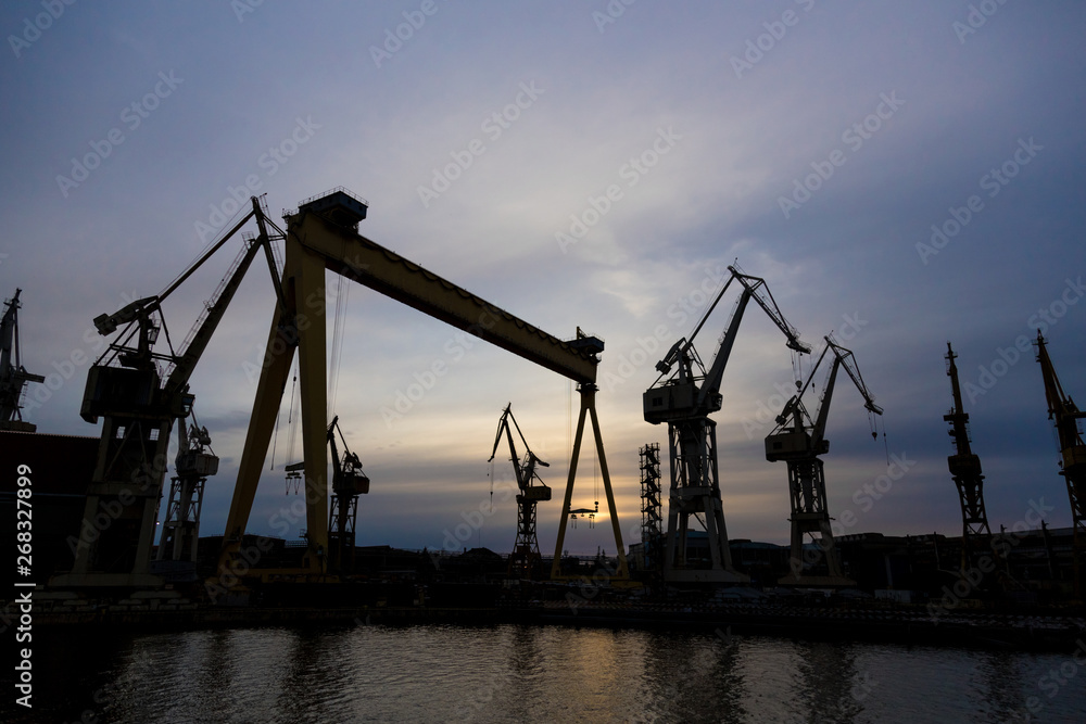 View on a shipyard with cranes at the sunset.