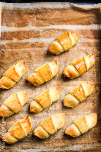Freshly baked french pastry croissants or rolls on baking tray