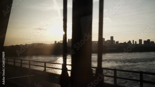 Wallpaper Mural The city of Montreal, Quebec, Canada seen through the windows of a train while it crosses a bridge - silhouette like shot during sunset. Torontodigital.ca